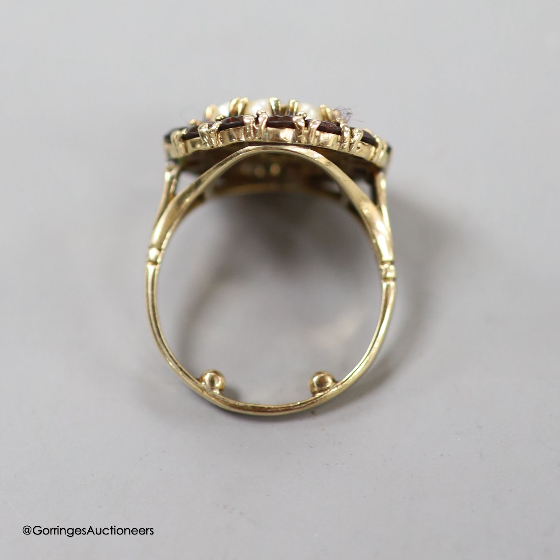 A modern 9ct gold, garnet and split pearl set circular cluster ring, size M, 5 grams.